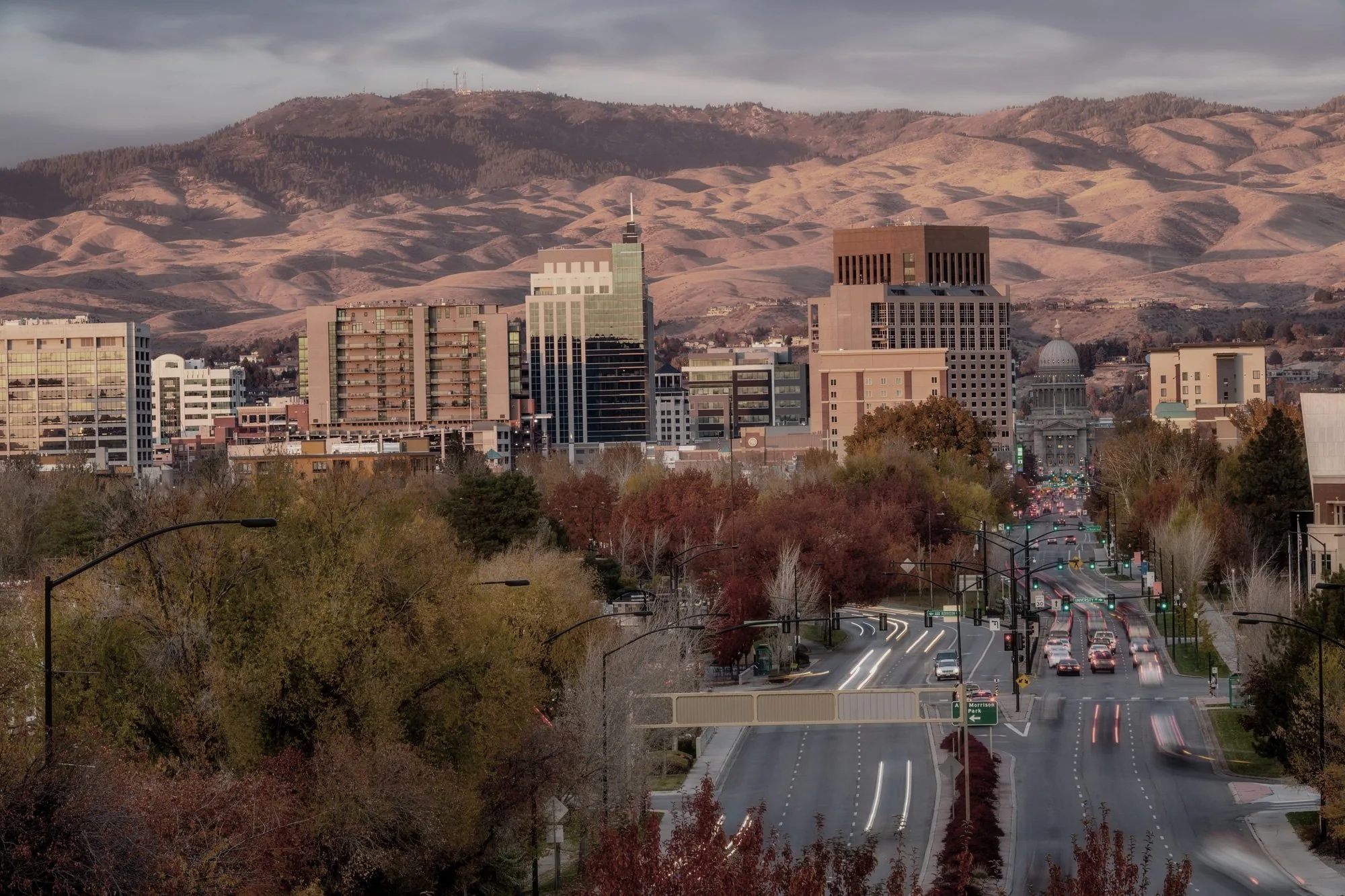 Downtown Boise, Idaho at dusk with the foothills in the background, looking up Capitol Boulevard toward the state capitol.